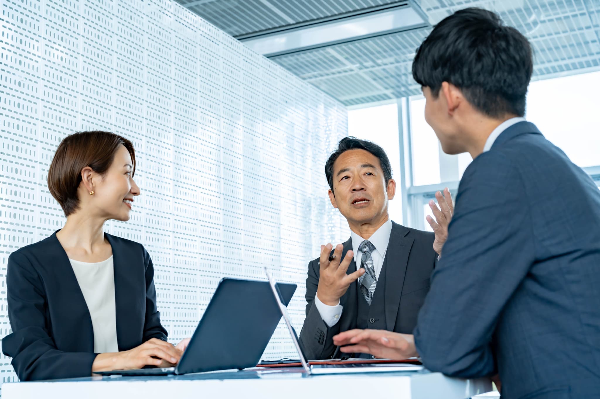 笑顔で打ち合わせをするコンサルタントと経営者